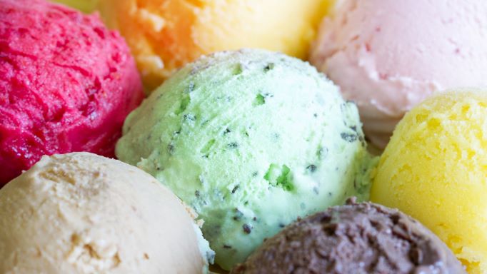 Several brightly colored scoops of ice cream in a bowl