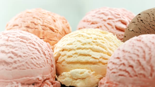 Several pale colored scoops of ice cream in a bowl