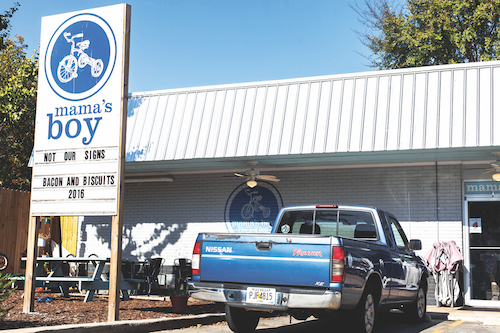 A picture of a restaurant named "Mama's Boy" and a blue truck sitting in front.