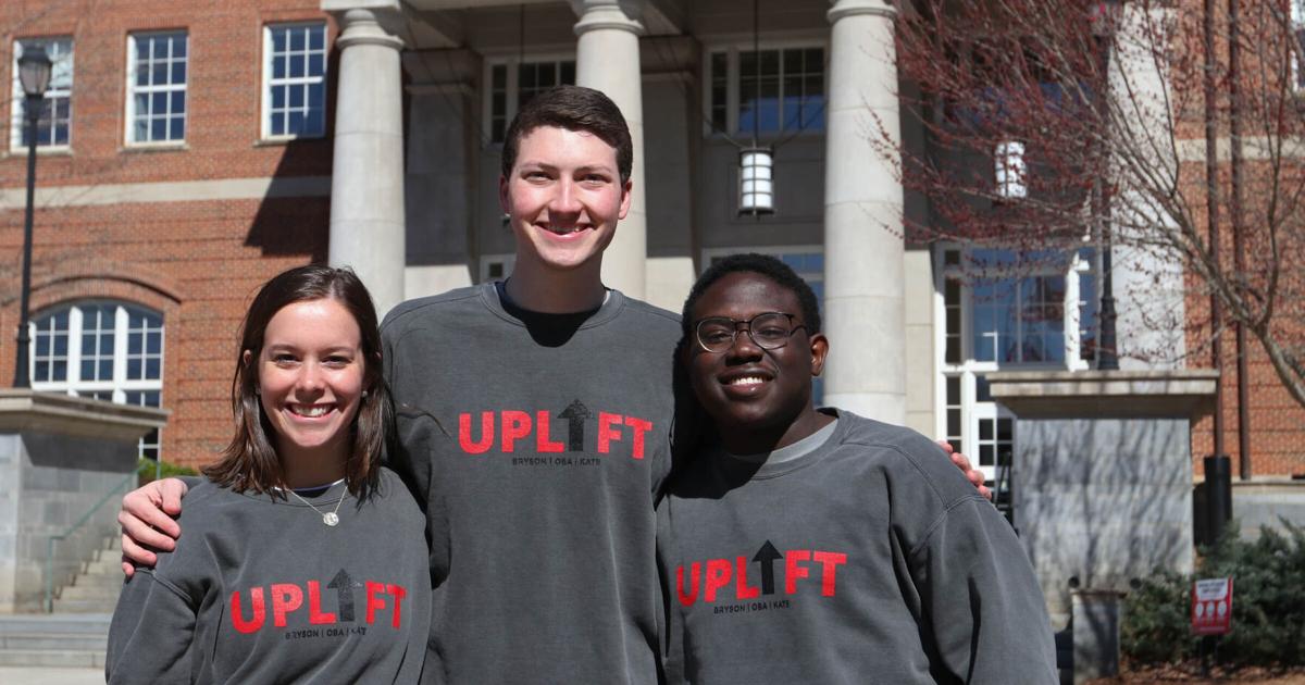 A picture of three people wearing sweatshirts that say "Uplift".